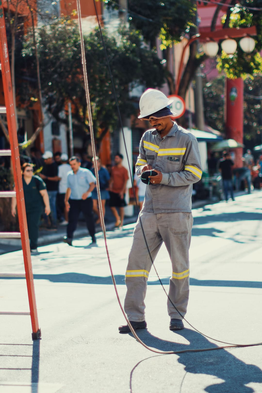 Técnico com capacete e uniforme refletivo trabalhando na rua